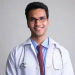portrait happy young handsome indian man doctor smiling studio shot against white background 137823661